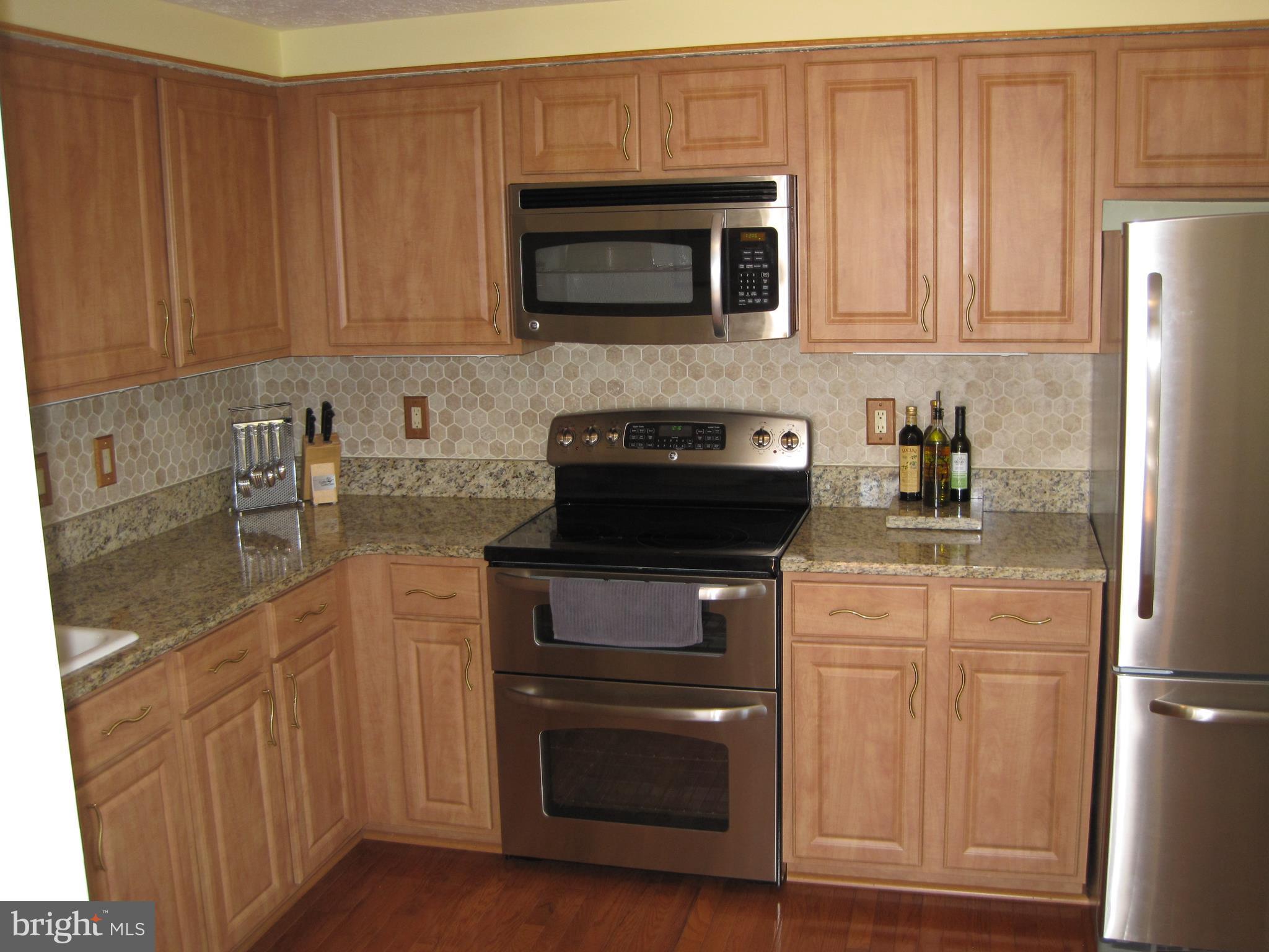 6178 Morning Glory Road Alexandria, VA 22310 - Photo 5 of 26 a kitchen with stainless steel appliances granite countertop a stove microwave and refrigerator