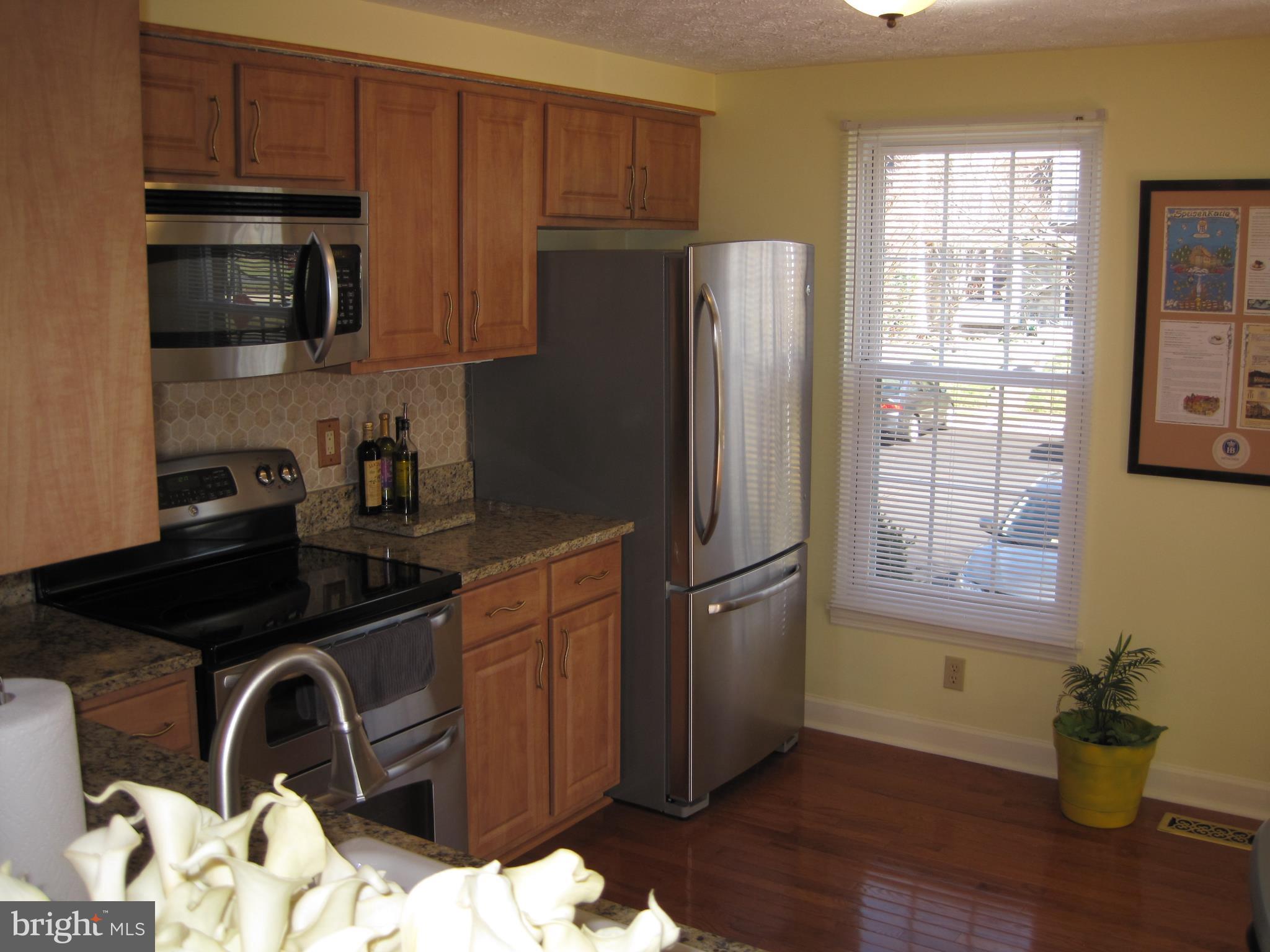 6178 Morning Glory Road Alexandria, VA 22310 - Photo 6 of 26 a kitchen with a refrigerator sink and wooden cabinets