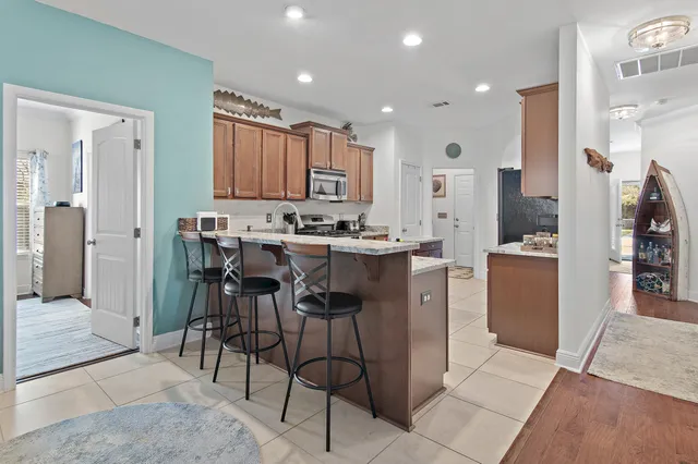 a kitchen with stainless steel appliances kitchen island granite countertop a refrigerator and a stove top oven