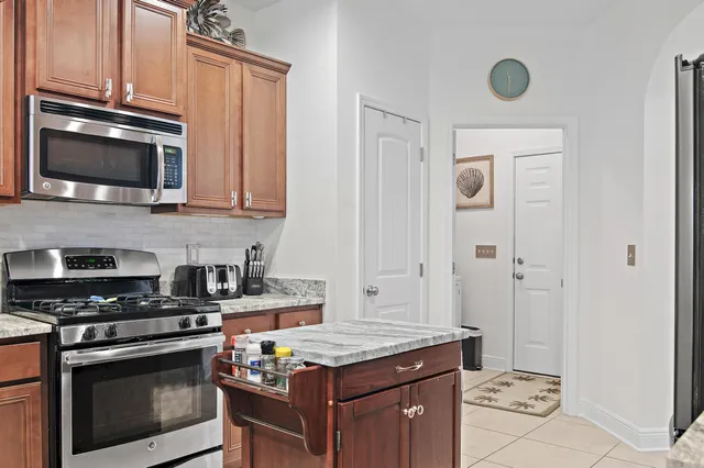 a kitchen with stainless steel appliances granite countertop a stove and a microwave