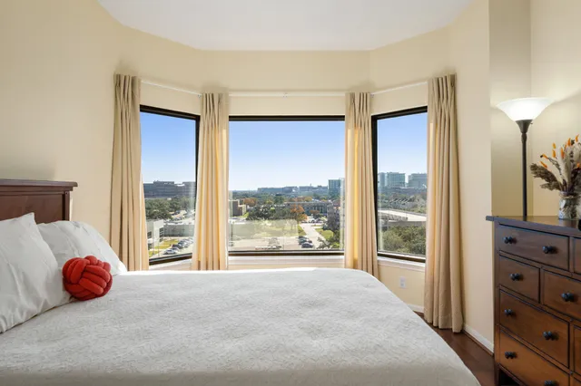 a bedroom with a bed and a large window