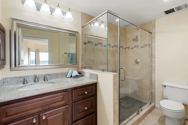 a bathroom with a granite countertop sink mirror toilet and shower