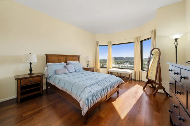 a bedroom with a bed a flat screen tv and a window