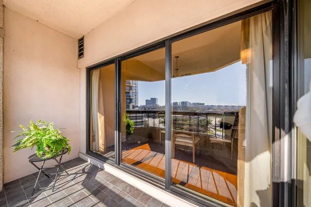 a view of a balcony with floor to ceiling windows with wooden floor