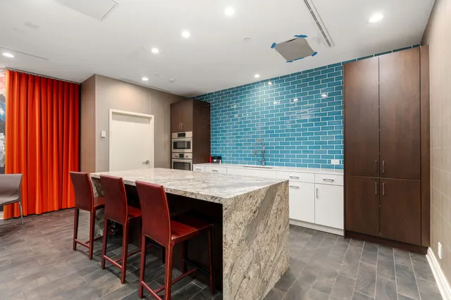 a kitchen with stainless steel appliances kitchen island granite countertop furniture a sink and a refrigerator
