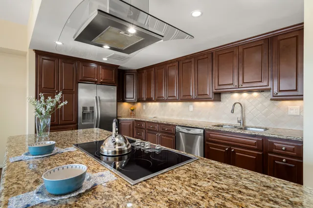 a kitchen with stainless steel appliances granite countertop a sink stove and refrigerator