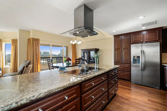 a kitchen with stainless steel appliances granite countertop a sink a oven and a refrigerator