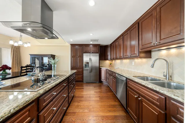 a large kitchen with stainless steel appliances granite countertop a sink and cabinets
