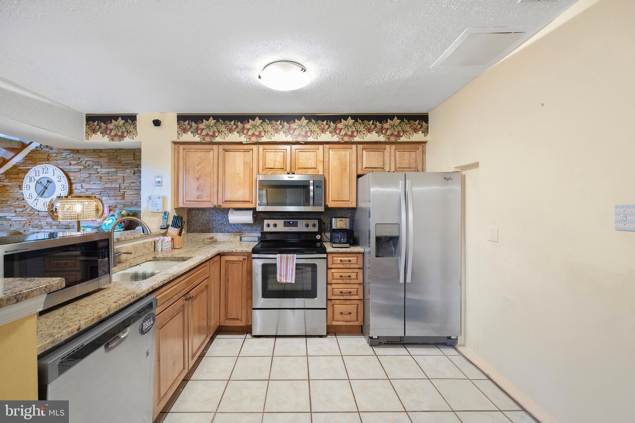 14106 William Street, Unit 19B Laurel, MD 20707 - Photo 12 of 31 a kitchen with a stove a sink and a microwave