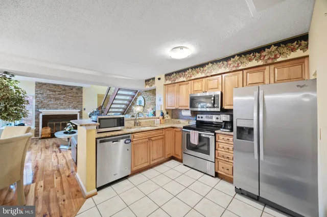 a kitchen with stainless steel appliances granite countertop a refrigerator and stove top oven