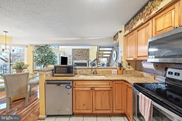 a kitchen with a stove a sink and a wooden cabinets