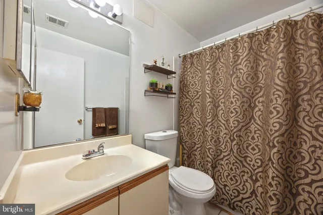 a bathroom with a sink toilet and a mirror