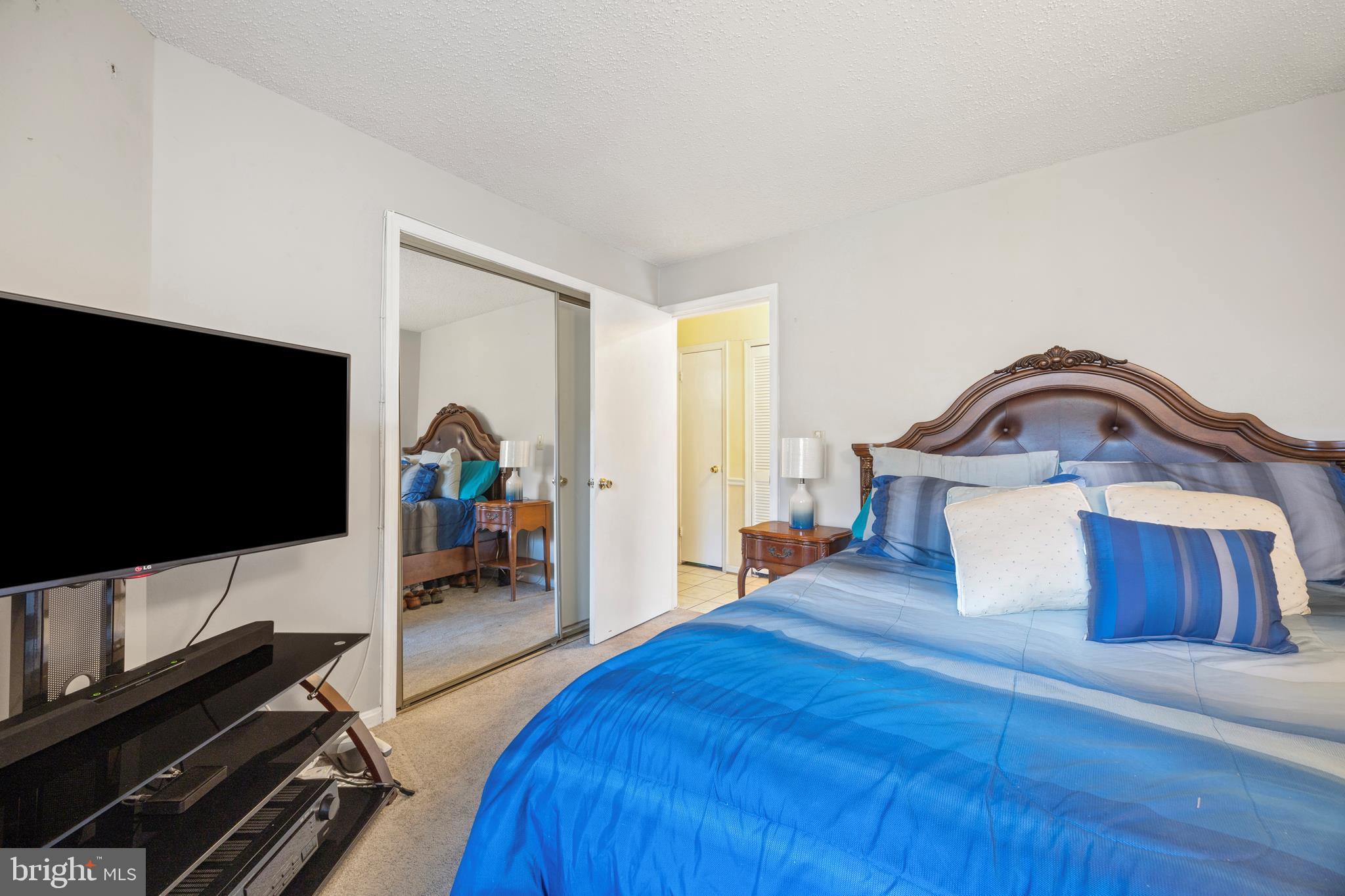 14106 William Street, Unit 19B Laurel, MD 20707 - Photo 22 of 31 a bedroom with a bed and a flat tv screen on the dresser