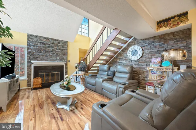 a living room with furniture a fireplace and a large window