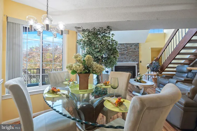 a dining room with furniture a chandelier and wooden floor