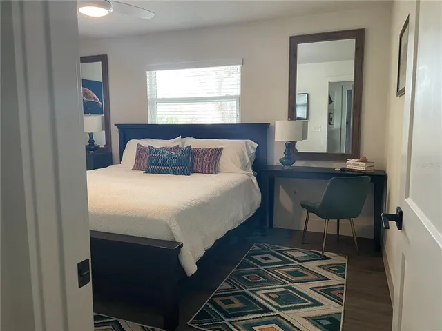 a bedroom with a bed and a mirror next to a window