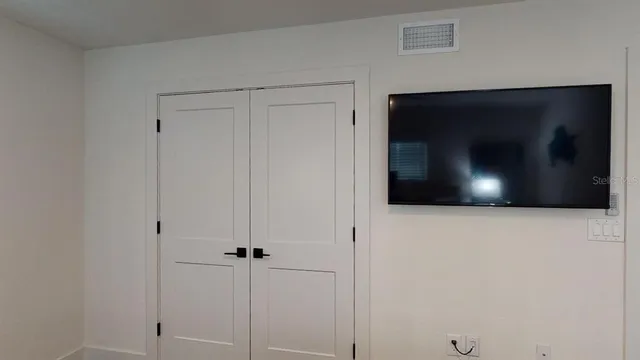 a bedroom with bed and wooden floor