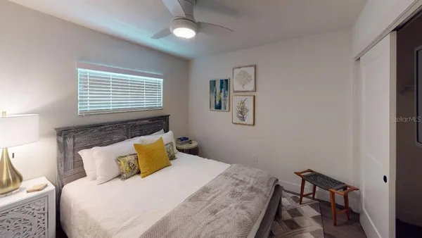 a bedroom with a bed a lamp and a large mirror