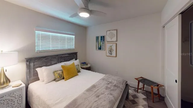 a bedroom with a bed a lamp and a large mirror
