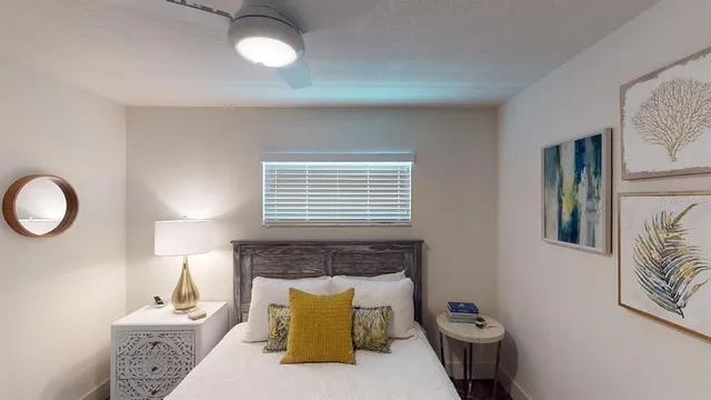 a living room with furniture a flat screen tv and a refrigerator