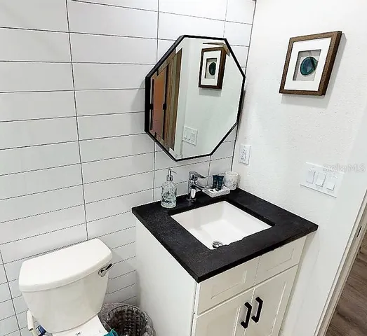 a bedroom with a bed and a lamp on the dresser