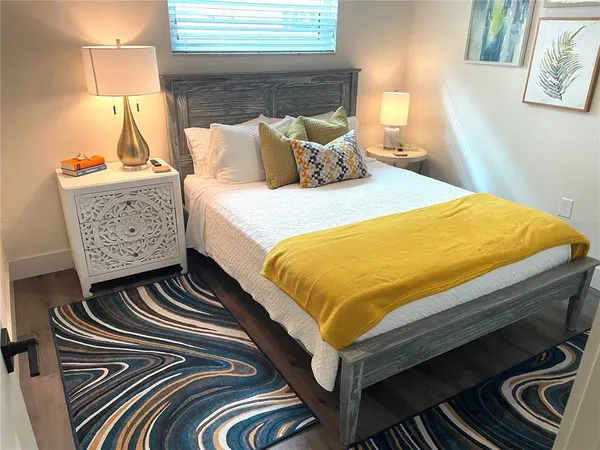 a bed sitting in a bedroom next to a lamp