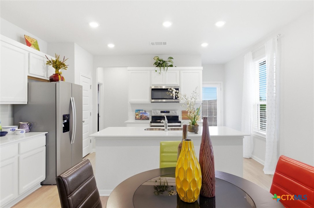 149 Cutleaf, Unit 31 San Marcos, TX 78666 - Photo 9 of 26 a kitchen with stainless steel appliances kitchen island granite countertop a refrigerator and a stove