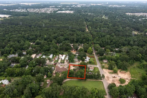 an aerial view of residential houses with outdoor space and trees