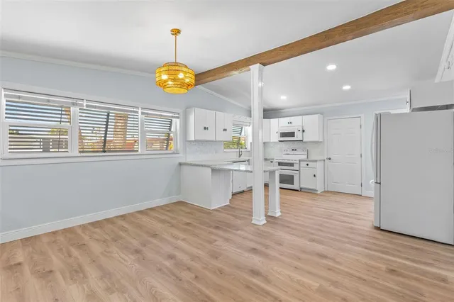a kitchen with cabinets appliances a sink and a window