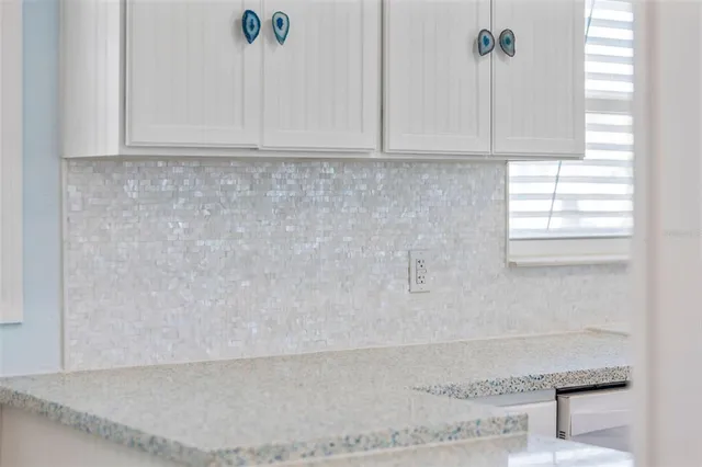 a living room with white cabinets and wooden floor