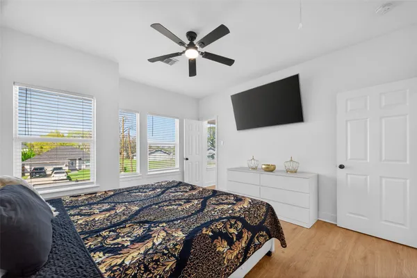 a bedroom with a bed window and a flat screen tv