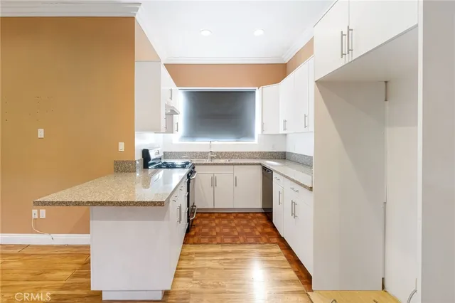a kitchen with kitchen island a stove and a wooden floor