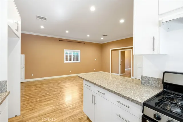 a view of a room with wooden floor and a ceiling fan
