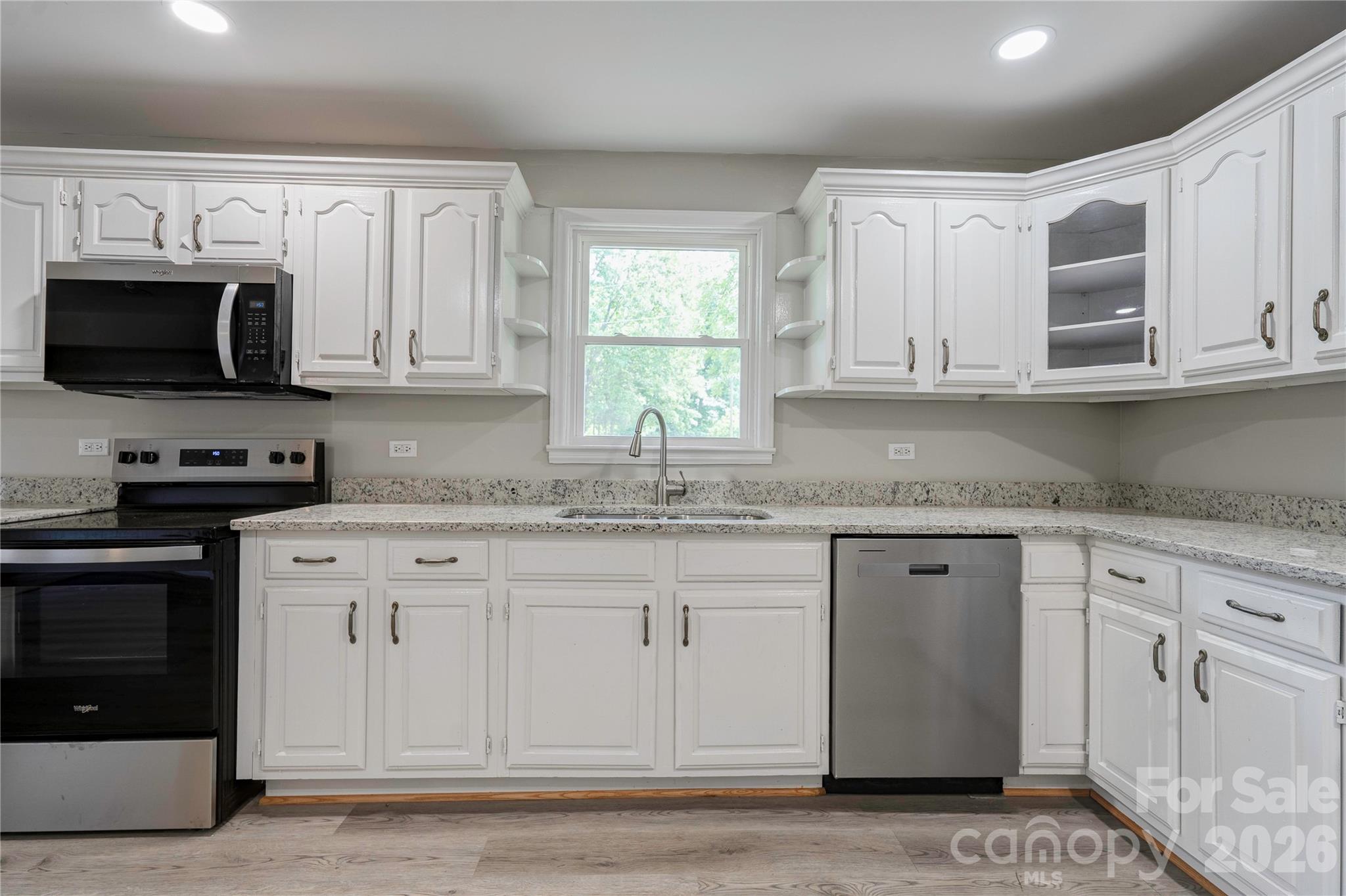 153 Greene Road Forest City, NC 28043 - Photo 12 of 23 a kitchen with granite countertop white cabinets sink and stainless steel appliances
