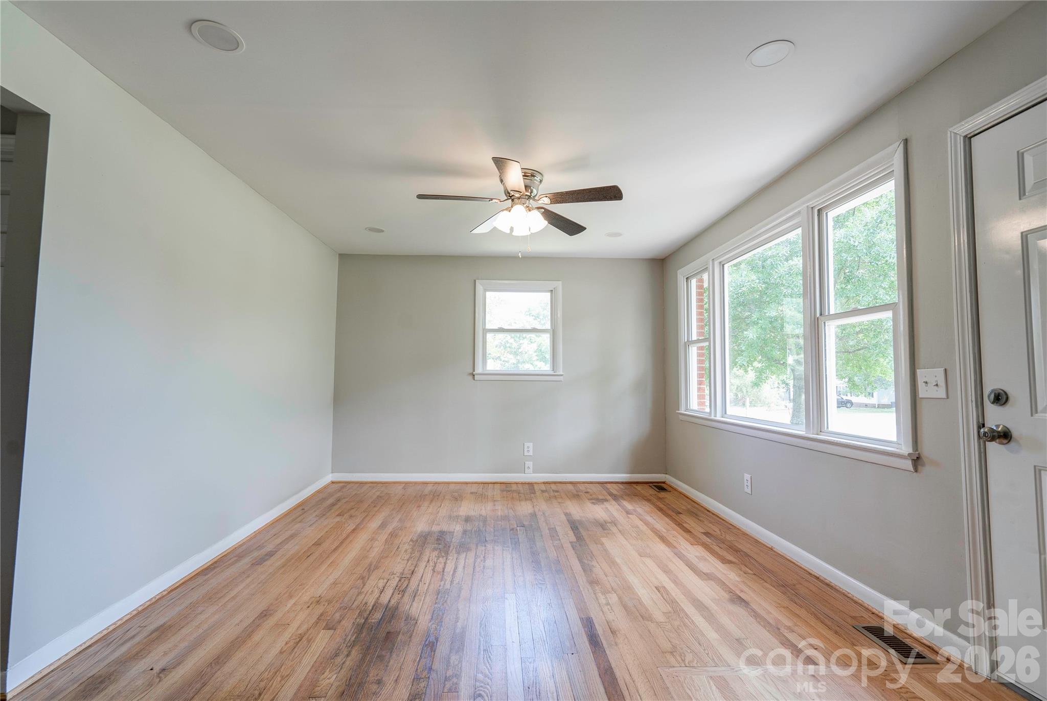 153 Greene Road Forest City, NC 28043 - Photo 7 of 23 an empty room with wooden floor and windows