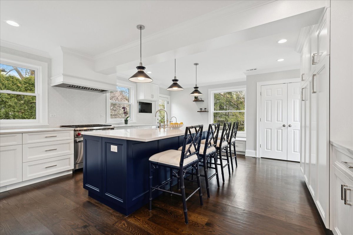 230 Oxford Road Kenilworth, IL 60043 - Photo 13 of 54 a kitchen with stainless steel appliances granite countertop a table chairs stove and wooden floor