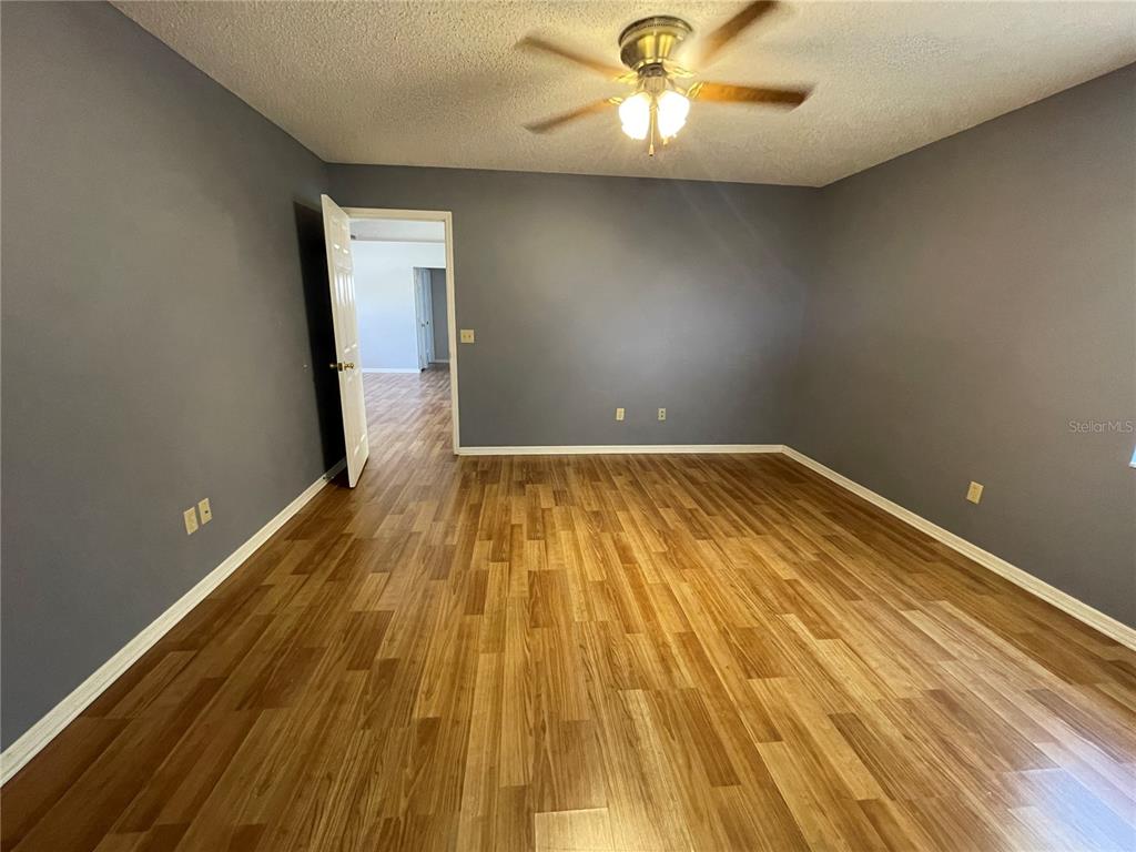 6034 East Peach Street Inverness, FL 34452 - Photo 12 of 16 an empty room with wooden floor and windows