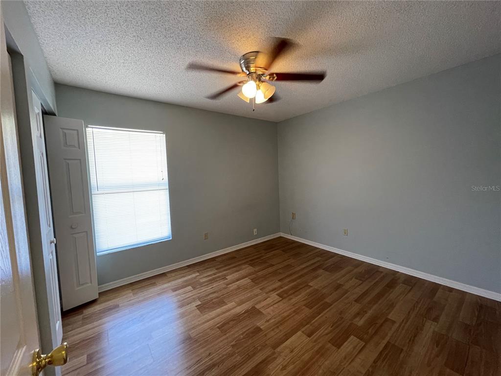 6034 East Peach Street Inverness, FL 34452 - Photo 7 of 16 an empty room with wooden floor fan and windows