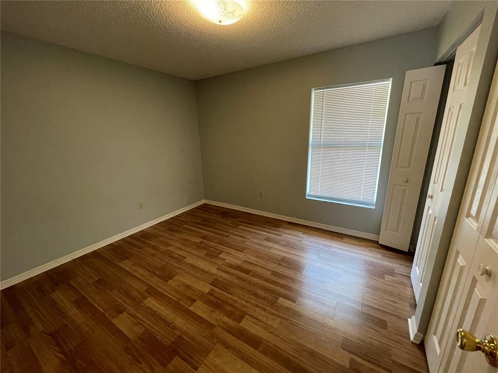 6034 East Peach Street Inverness, FL 34452 - Photo 9 of 16 an empty room with wooden floor and windows