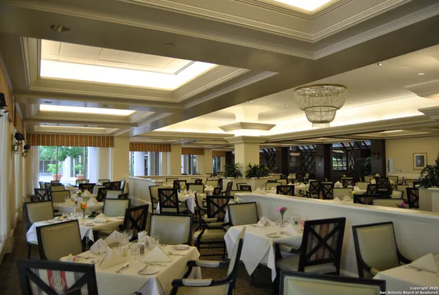 a very nice looking living room with dining room and lots of tables a chandelier