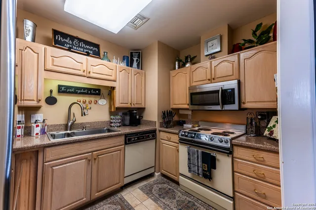 a kitchen with stainless steel appliances granite countertop a stove a sink and a microwave