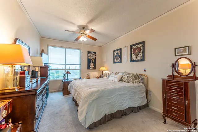a bedroom with a bed next to a window and a flat screen tv