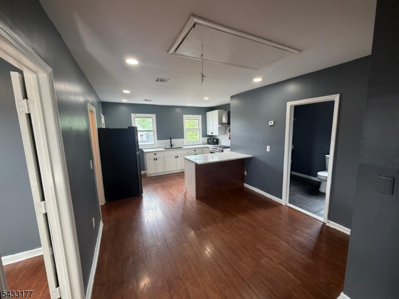 166 Renner Avenue, Unit 3 Newark, NJ 07112 - Photo 4 of 24 a kitchen with stainless steel appliances granite countertop a refrigerator a sink dishwasher a stove and white countertops with wooden floor