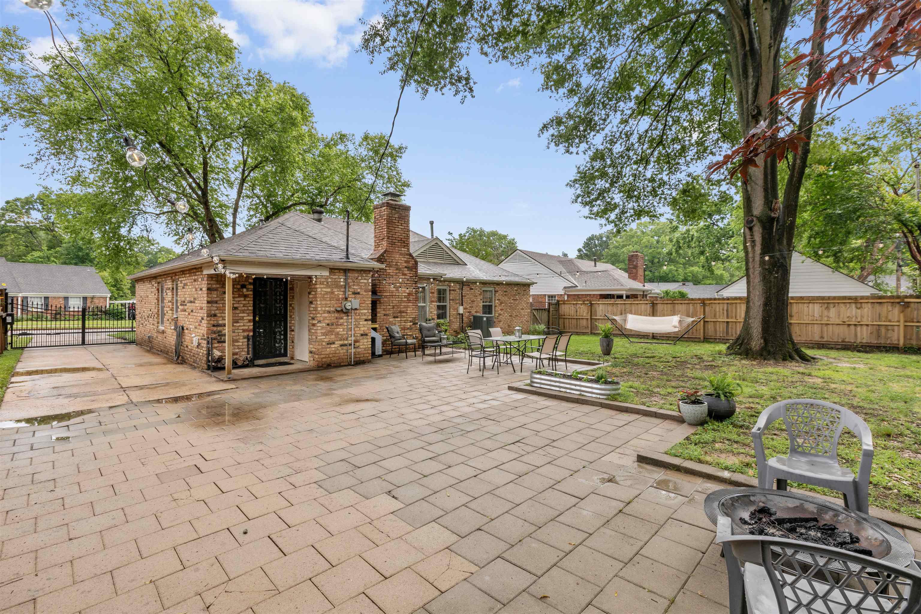 5585 Milam Road Memphis, TN 38120 - Photo 23 of 24 a view of a patio with table and chairs under an umbrella with large trees