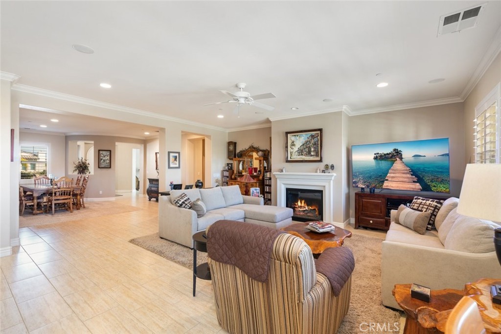 227 Tom McGuinness Jr Circle Fallbrook, CA 92028 - Photo 12 of 42 a living room with furniture a fireplace and a dining table with wooden floor