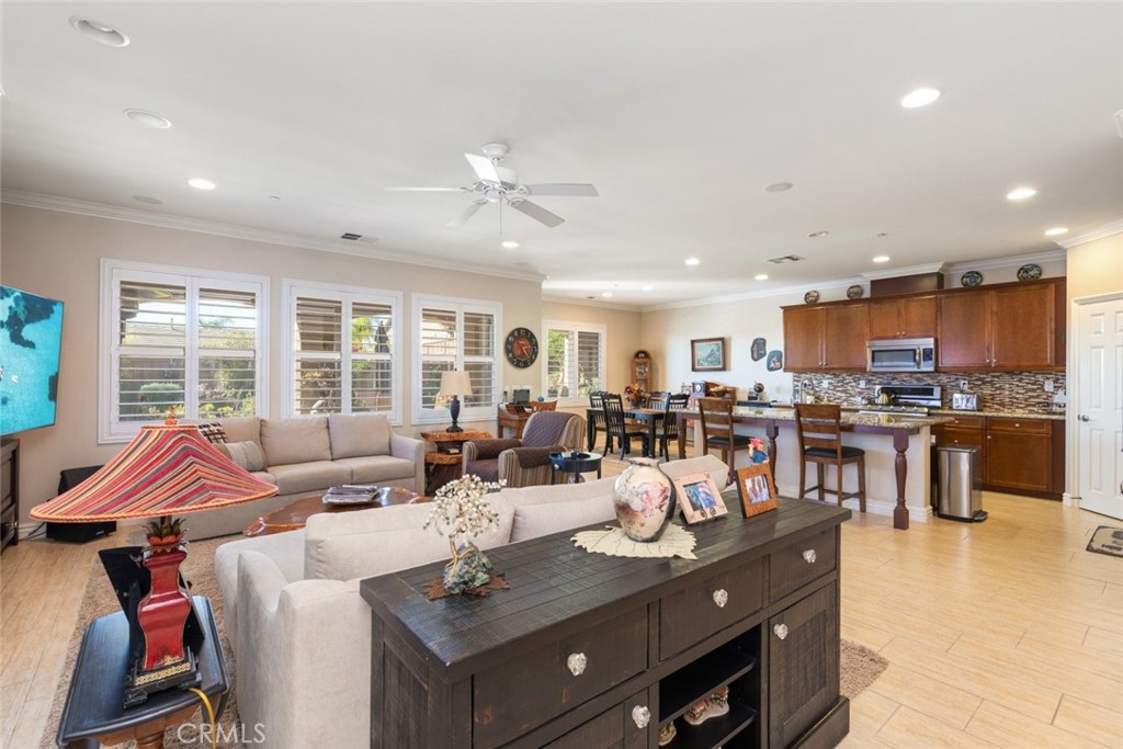 227 Tom McGuinness Jr Circle Fallbrook, CA 92028 - Photo 13 of 42 a living room with stainless steel appliances kitchen island granite countertop a table chairs and a refrigerator