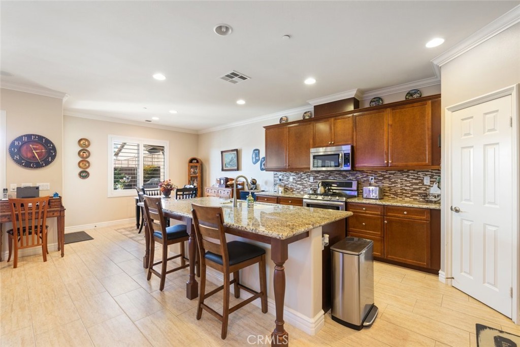 227 Tom McGuinness Jr Circle Fallbrook, CA 92028 - Photo 14 of 42 a kitchen with stainless steel appliances granite countertop table chairs sink and cabinets