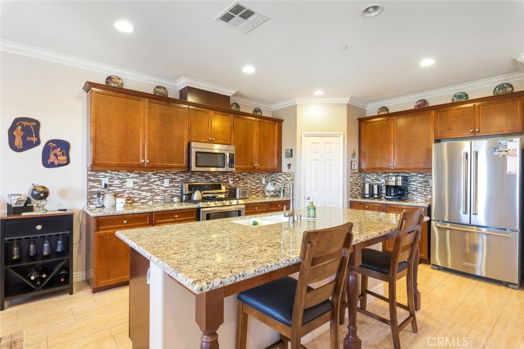 227 Tom McGuinness Jr Circle Fallbrook, CA 92028 - Photo 16 of 42 a kitchen with a table chairs refrigerator and microwave