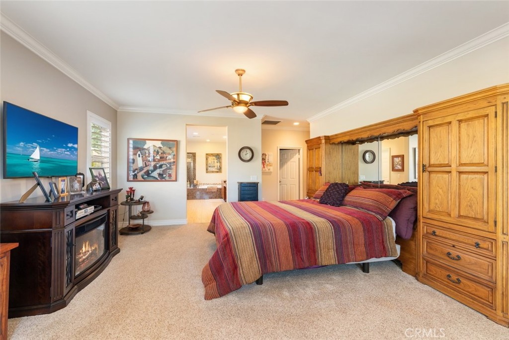 227 Tom McGuinness Jr Circle Fallbrook, CA 92028 - Photo 26 of 42 a spacious bedroom with a bed and a flat screen tv