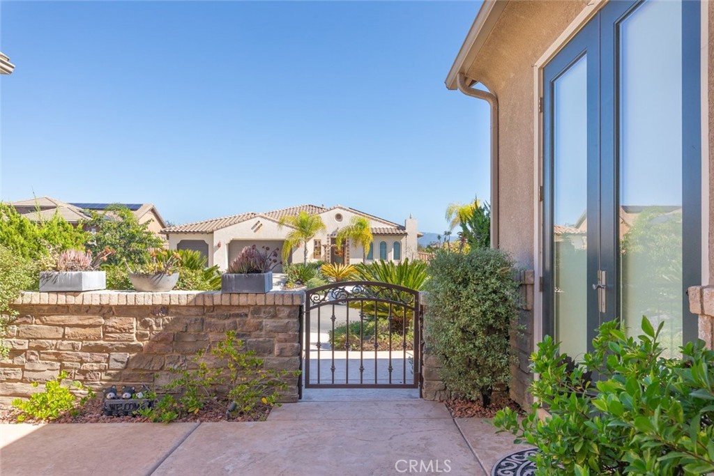 227 Tom McGuinness Jr Circle Fallbrook, CA 92028 - Photo 31 of 42 a view of a house with a small yard and floor to ceiling window and potted plants